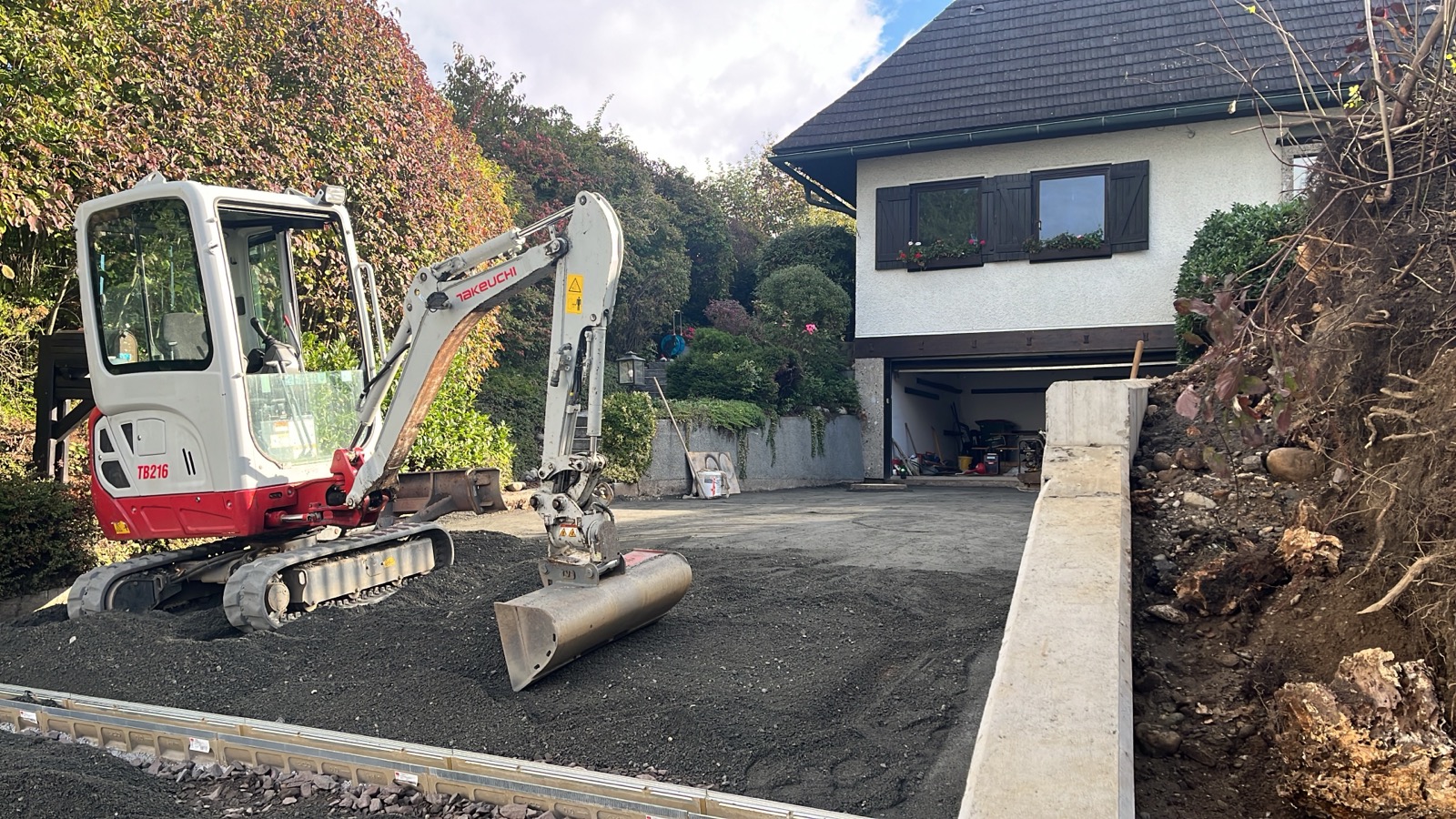 Bagger bei Einfahrtsgestaltung mit Schotterunterbau